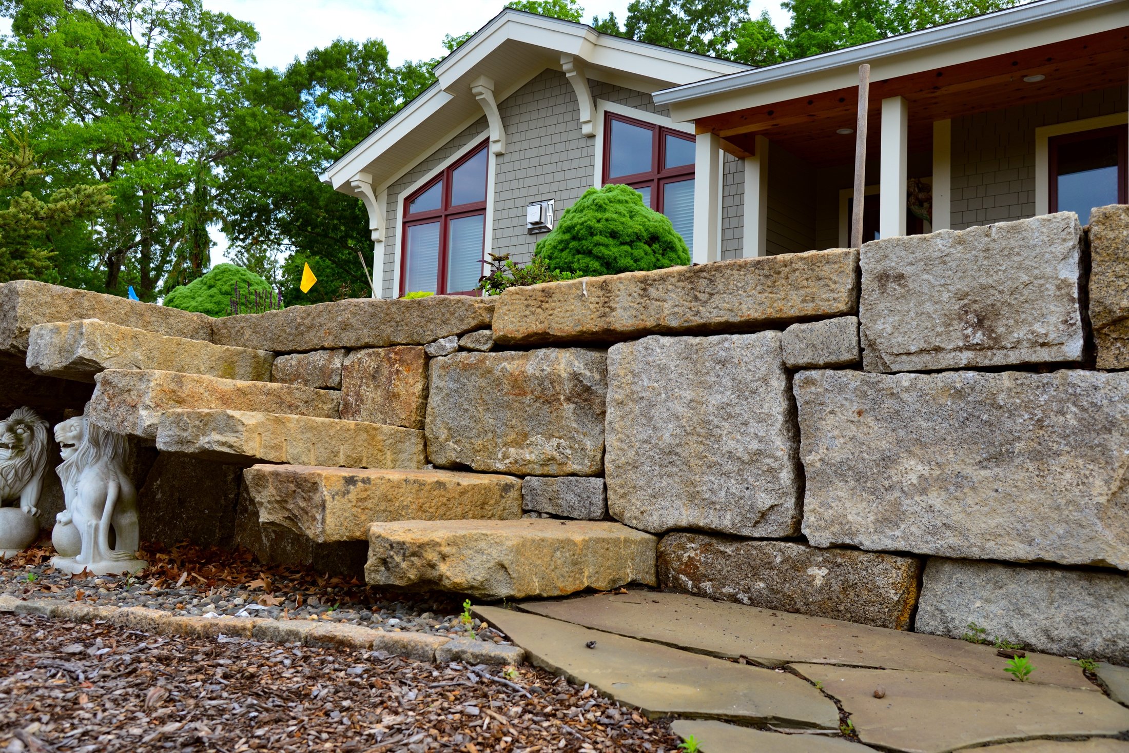 Large boulder retaining wall with stone slab steps