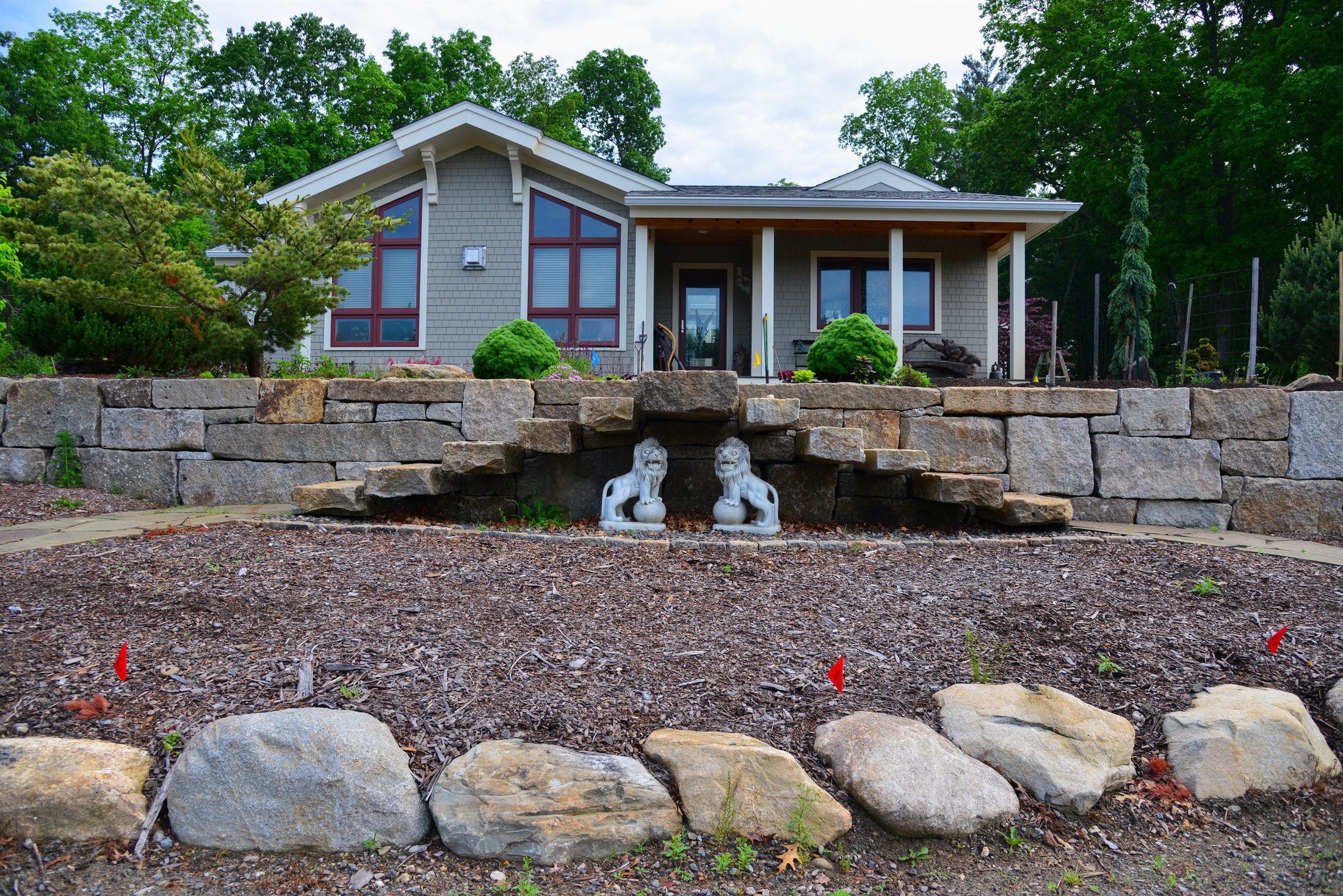 Modern home with tiered boulder retaining walls