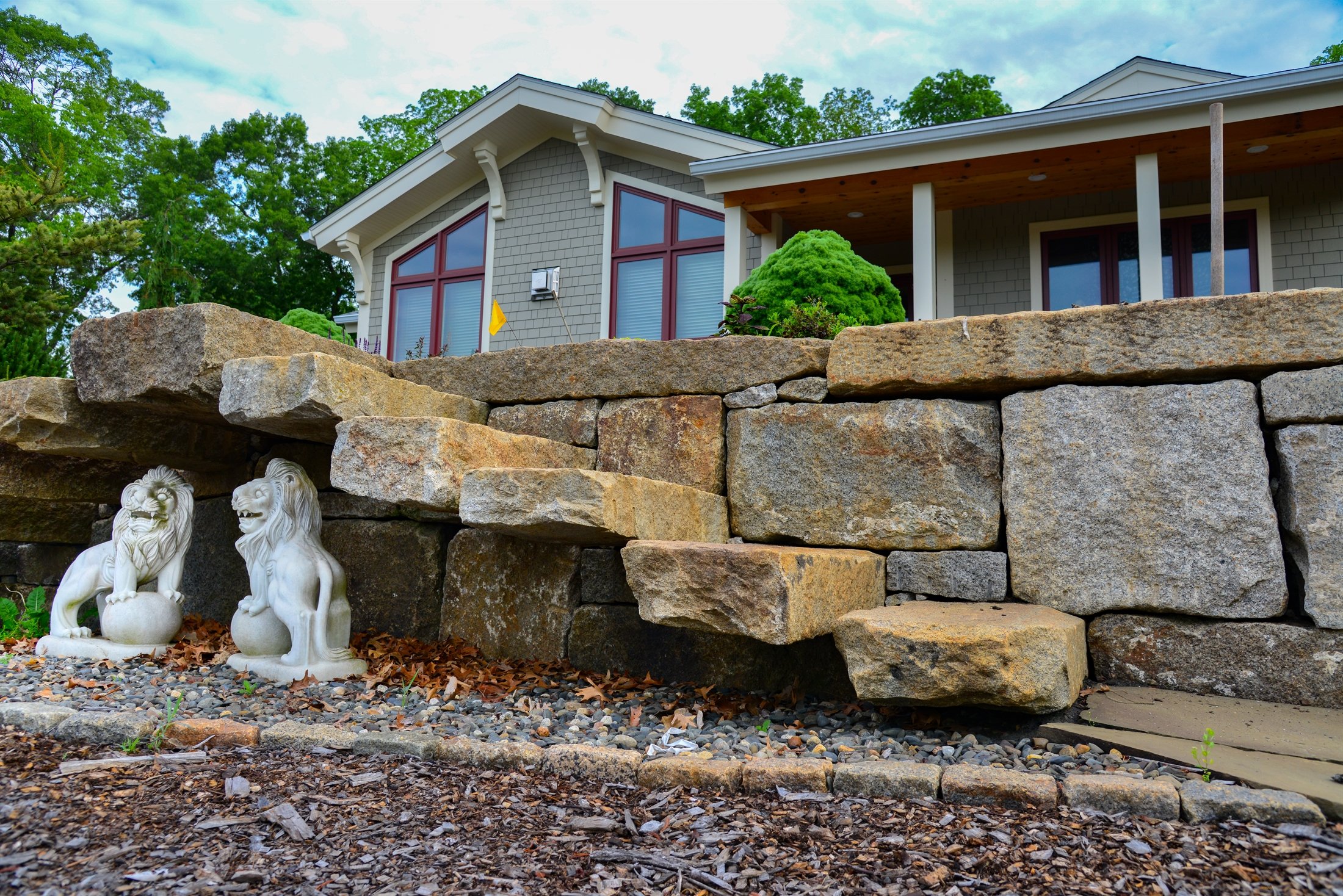 Stone retaining wall with integrated steps and lion statues
