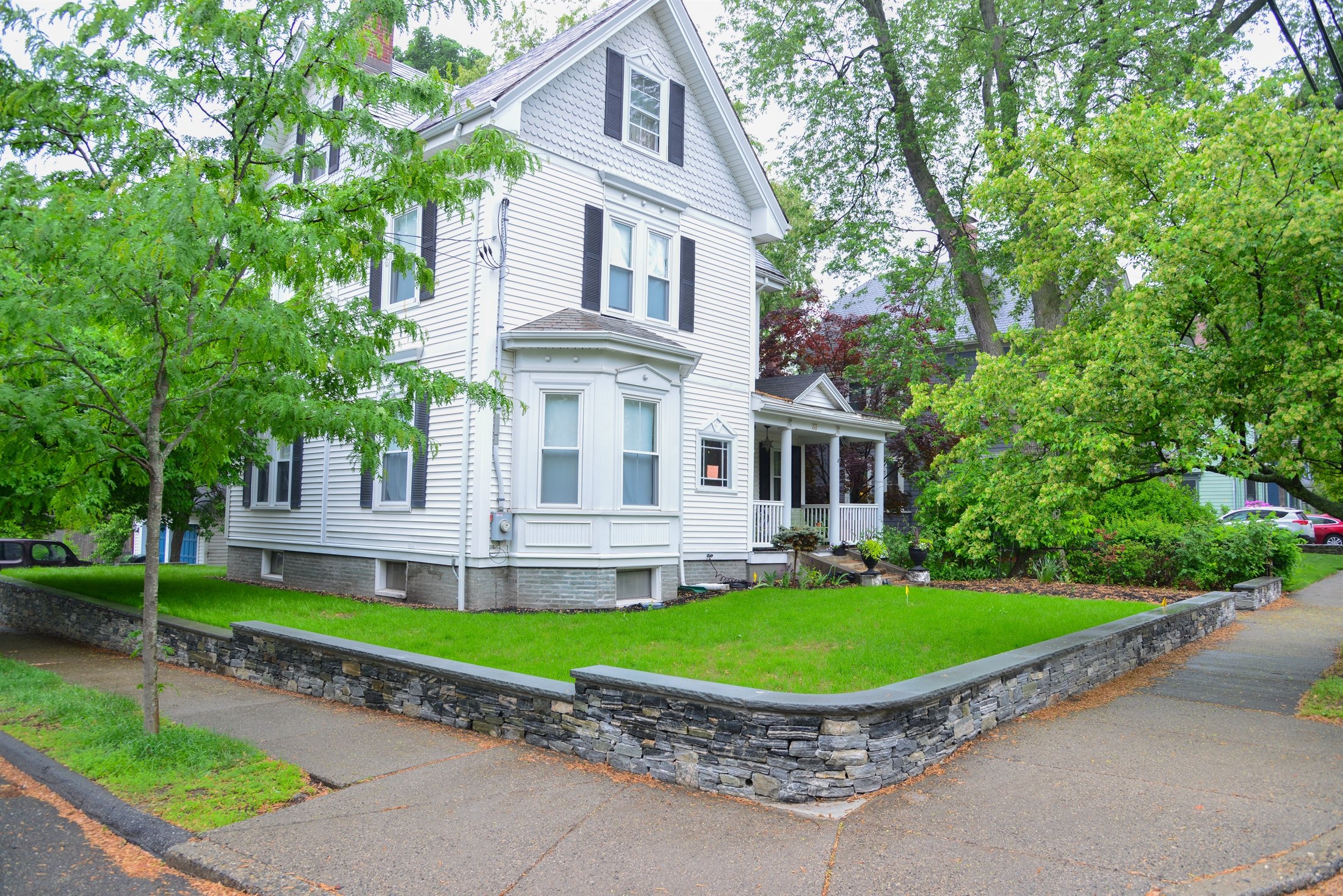 Victorian home with slate retaining wall and lush lawn